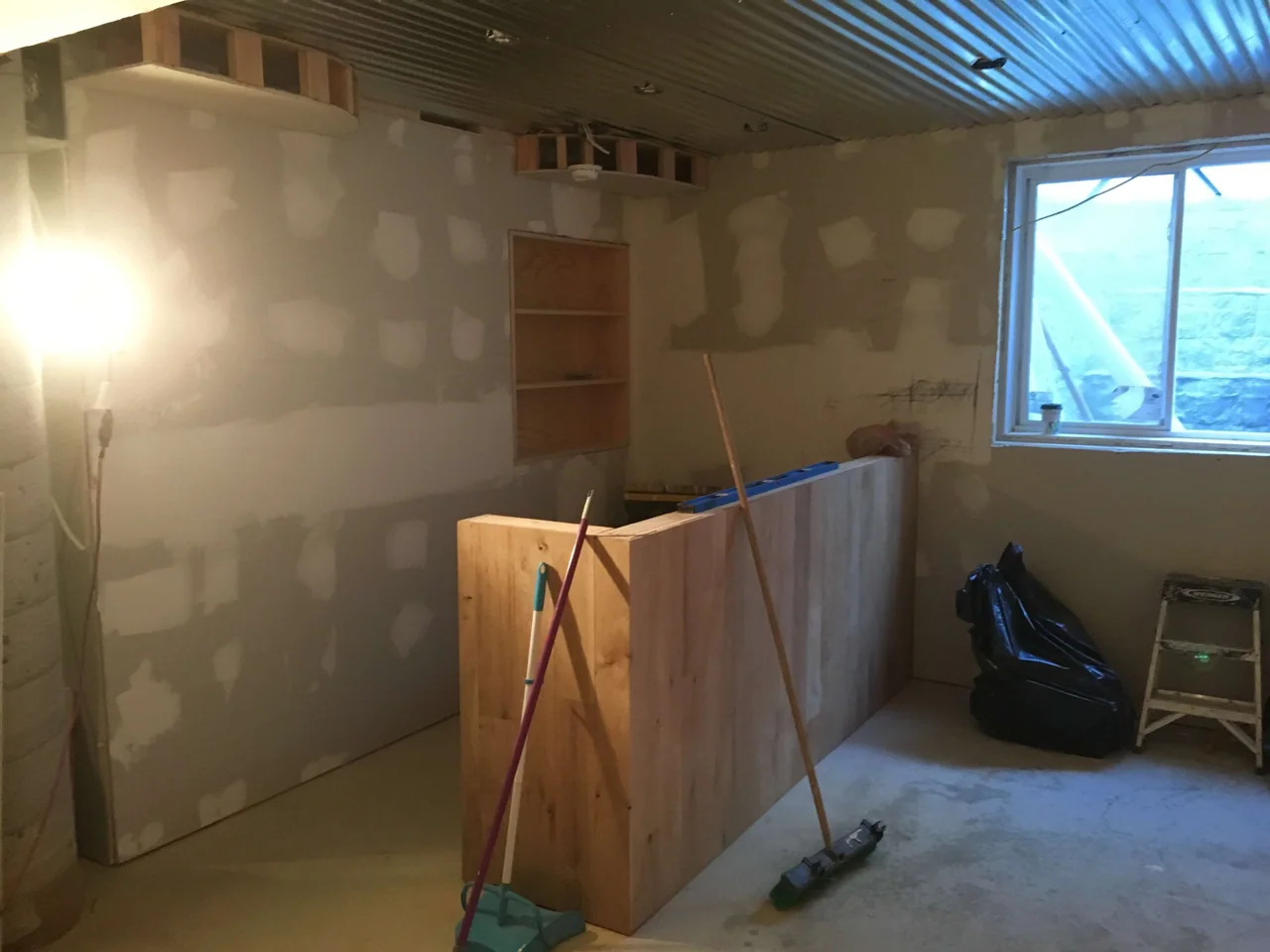 Basement finishing in progress with new drywall, framing, and work area prep