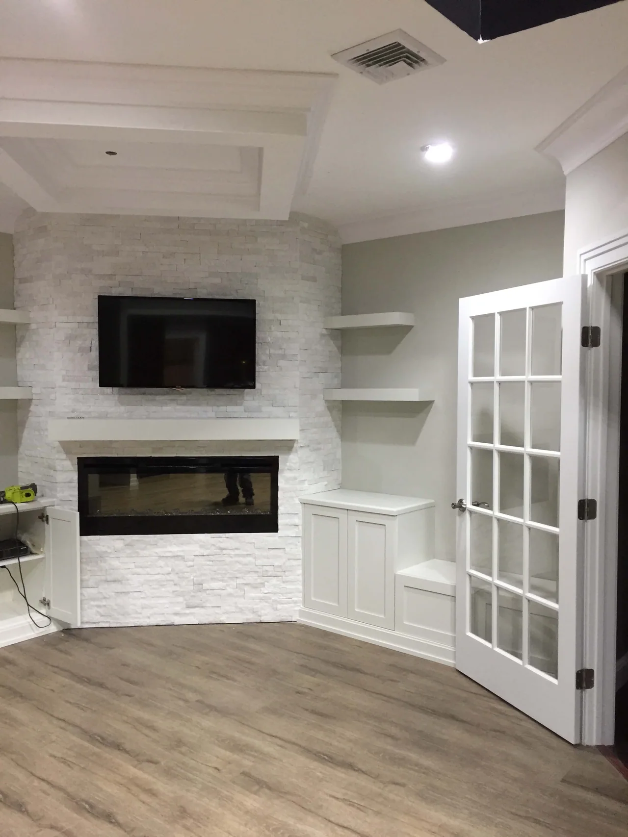 Finished basement living area with trim, flooring, and built-ins